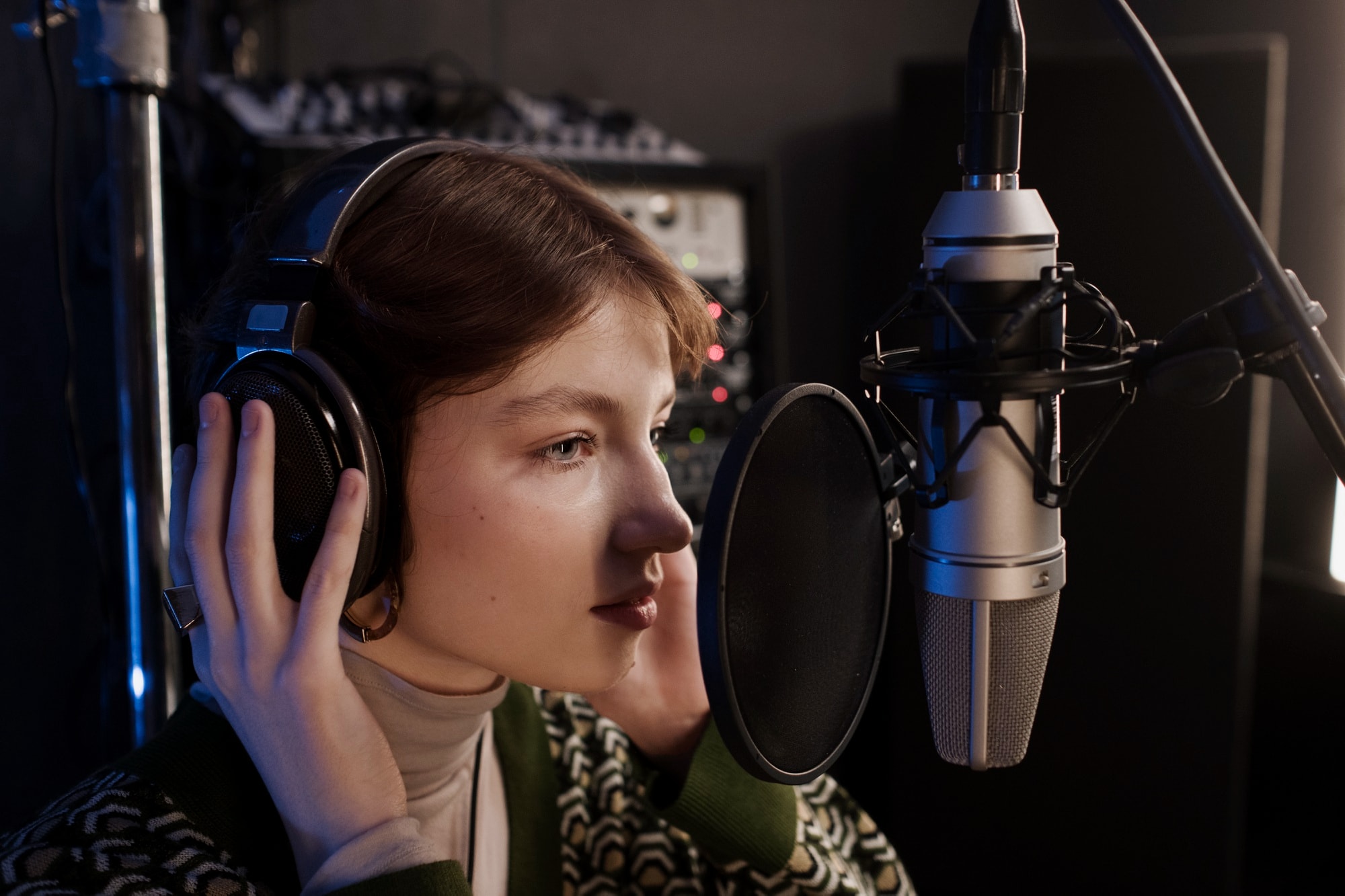 Singer recording vocals on a studio microphone with headphones